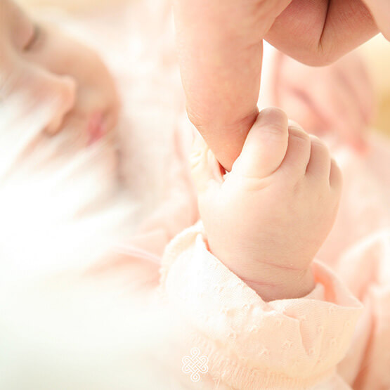 Bébé attrapant un doigt, illustrant les réflexes archaïques et le développement moteur
